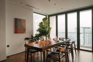 une salle à manger avec une table, des chaises et des fenêtres dans l'établissement Sunset view Sky Villa in Ecopark resort with private pool, à Cong Luận