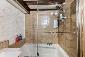 a bathroom with a tub and a shower at Cascades Cottage in Blaenau-Ffestiniog +19 photos