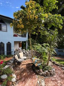 a patio with chairs and a tree in a yard at Hotel Isla Verde in Boquete