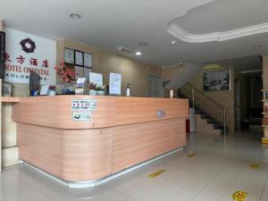 un restaurant avec un comptoir en bois dans un bâtiment dans l'établissement Dancenter Hotel Oriental, à Kota Kinabalu