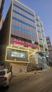 Un edificio alto con un cartel en el frente. en فندق ربوة الصفوة ريع بخش, en Ajyad