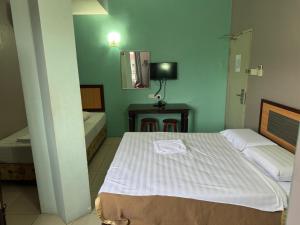 - une chambre avec un lit et une table avec un miroir dans l'établissement Dancenter Hotel Oriental, à Kota Kinabalu 23 autres photos