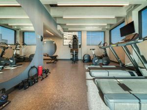 a gym with several treadmills and machines in a room at Novotel SP Jardins in Sao Paulo