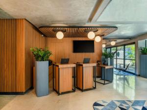 a lobby with two desks and a television on the wall at Novotel SP Jardins in Sao Paulo