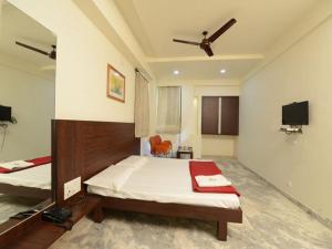 1 Schlafzimmer mit 2 Betten und einem Flachbild-TV in der Unterkunft Hotel Rahi Inn in Vadodara