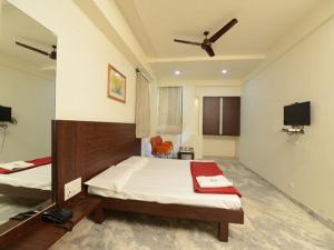 a bedroom with two beds and a flat screen tv at Hotel Rahi Inn in Vadodara