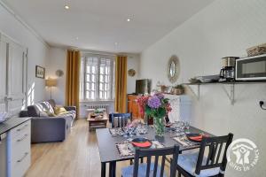 una cucina e un soggiorno con tavolo e sedie di Le safran a Dinard