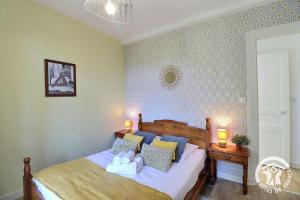 una camera da letto con un letto con cuscini sopra di Le safran a Dinard