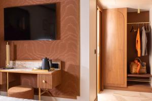 a bedroom with a desk and a television on a wall at Hôtel Filigrane & Spa in Paris
