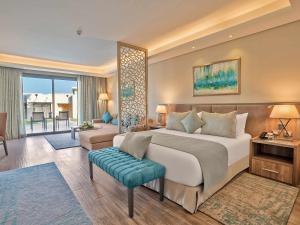 Un dormitorio con una cama grande y una sala de estar. en Rixos Premium Magawish Suites and Villas- Ultra All-Inclusive, en Hurghada