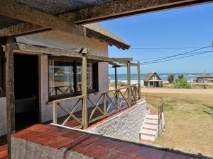 プンタ・デル・ディアブロにあるCasa TANIKAの海岸の景色を望むポーチ付きの建物