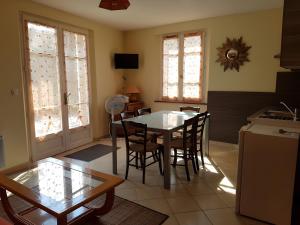 a kitchen and dining room with a table and chairs at Gîte La Combe Verte in Ratières