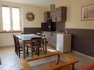 a kitchen with a table and chairs and a refrigerator at Gîte La Combe Verte in Ratières
