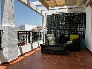 a balcony with chairs and a table on a building at Atico playa de Rota in Rota