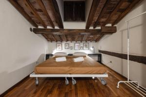 une chambre avec un lit dans une pièce avec des plafonds en bois dans l'établissement Single House - Pisa, à Pise