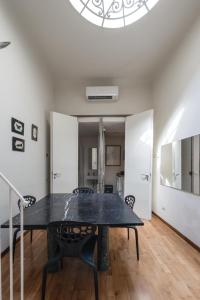 une salle à manger avec une table et des chaises noires dans l'établissement Single House - Pisa, à Pise