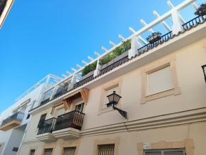 ロタにあるEstudio ático centro Rotaの植物が植えられたバルコニー付きの建物