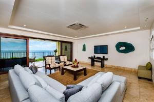 a living room with a large couch and a television at Beachfront Oceanview Private Jacuzzi & Full Ktcn in Tamarindo