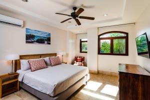 a bedroom with a bed and a ceiling fan at Beachfront Oceanview Private Jacuzzi & Full Ktcn in Tamarindo +17 photos