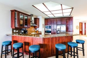 a kitchen with a counter with blue stools at Beachfront Oceanview Private Jacuzzi & Full Ktcn in Tamarindo