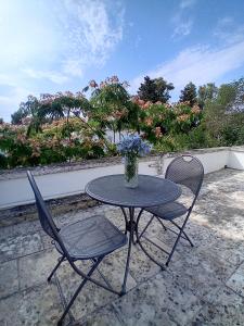 a table and chairs on a patio with a vase of flowers at Sud e Sole in Arnesano +14 photos