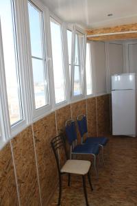 ネヴィンノムイスクにあるКвартиры Калинина 161Аの椅子、冷蔵庫、窓が備わる客室です。