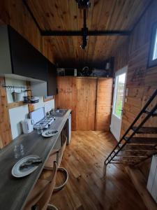 a kitchen with wooden walls and a wooden floor at Tiny House LA TITITINY in Molines