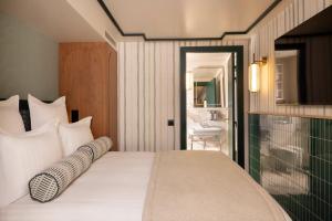 a bedroom with a bed and a bathroom with a sink at Hôtel Filigrane & Spa in Paris