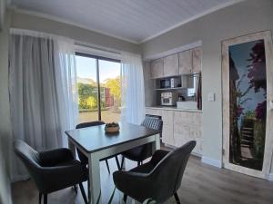a kitchen and dining room with a table and chairs at Kaaimans Crest Sea-View Apartments - Great Brak River in Groot Brak Rivier