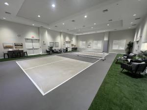 a tennis court in a room with a tennis racket at LIC Mgr - LUXURIOUS 2 BED 3 BATH OCEANFRONT SUITE - UPSCALE OCEANFRONT RESORT - INDOOR PICKLEBALL - SPEAKEASY! in Key Largo
