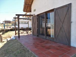 プンタ・デル・ディアブロにあるCasa TANIKAのスライドドアとパティオ付きの家