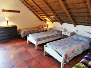 プンタ・デル・ディアブロにあるCasa TANIKAのベッド2台、テーブル2台、ランプ2つが備わるお部屋