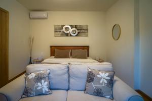 a bedroom with a bed and a couch with pillows at 1951 Suites in Kalabaka +51 photos