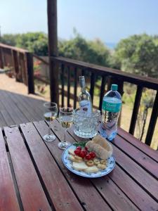 a plate of food and glasses of wine on a wooden table at Casa Baleia Azul 8A Ponta Mamoli in Ponta Mamoli +6 photos