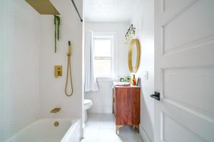 a bathroom with a tub and a toilet and a sink at Prime Location Top Rated Clean Parking Free! in Columbus