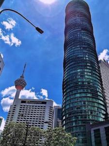 a tall glass building with a view of the space needle at Vortex Suites Klcc By lucky Star in Kuala Lumpur