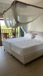 a bed with a canopy in a bedroom at Casa Baleia Azul 8A Ponta Mamoli in Ponta Mamoli