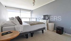 een slaapkamer met een bed en een tafel erin bij Live a Beach Life in the Heart of La Serena! in La Serena