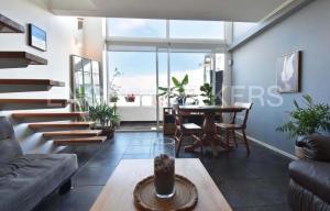 een woonkamer met een trap en een tafel bij Live a Beach Life in the Heart of La Serena! in La Serena