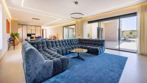 ein Wohnzimmer mit einem großen Sofa und einem blauen Teppich in der Unterkunft Villa Gaspard - Piscine et jardin Privée Sans vis-à-vis Wifi HD in Oulad Akkou