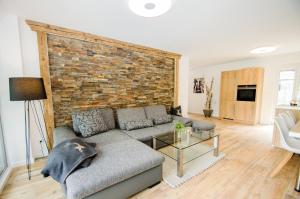 ein Wohnzimmer mit einer Couch und einer Ziegelwand in der Unterkunft Penthouse Waterside by All in One Apartments in Zell am See