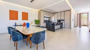 ein Esszimmer und eine Küche mit Tisch und Stühlen in der Unterkunft Villa Gaspard - Piscine et jardin Privée Sans vis-à-vis Wifi HD in Oulad Akkou