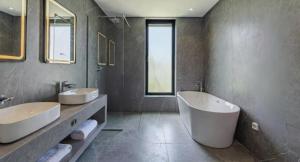 ein Badezimmer mit zwei Waschbecken und einer großen Badewanne in der Unterkunft Villa Gaspard - Piscine et jardin Privée Sans vis-à-vis Wifi HD in Oulad Akkou + 18 Fotos