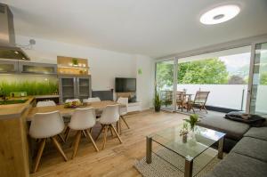 ein Wohnzimmer mit einer Couch und einem Tisch und Stühlen in der Unterkunft Penthouse Waterside by All in One Apartments in Zell am See