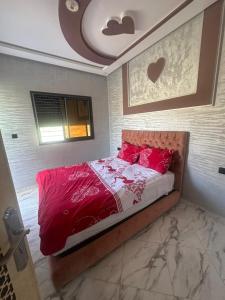 a bedroom with a bed with red sheets and pillows at اقامة قرب حمام my yaacup in Moulay Yacoub +20 photos