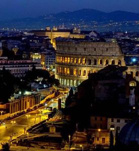a view of a city at night with lights at REALE COLOSSEUM HOME - private garden in Rome