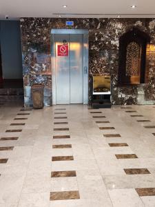 a metal elevator in a room with a stone wall at APARTMENT near GULF DELMON in Dammam