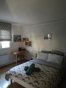 Un dormitorio con una cama con una almohada verde. en Chambre d'Hôtes Valérie, en Penvénan 3 fotos más