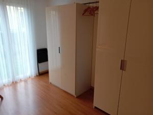 a white cabinet in a room with a wooden floor at Familienzimmer Bremgarten in Bremgarten