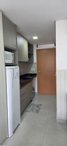 una cocina con nevera y microondas en Villas do Porto Residence by La Playa, en Porto de Galinhas